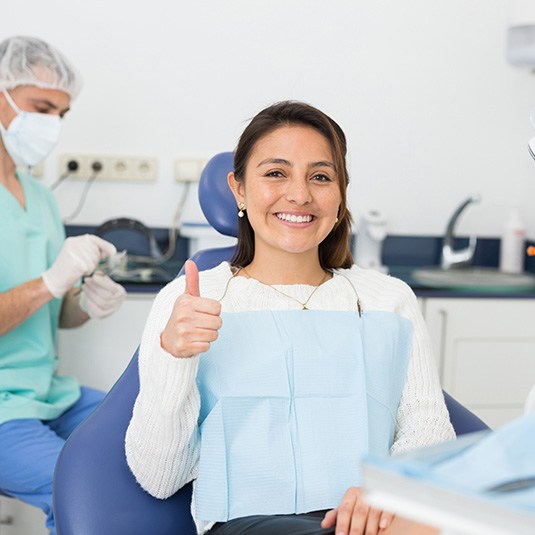 Happy female dental patient making thumbs up gesture